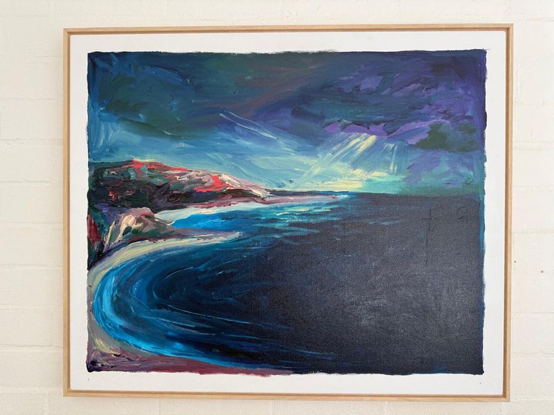A framed painting of a blue coastline